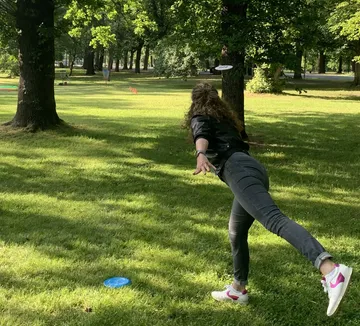 Person spielt Discgolf im Park.