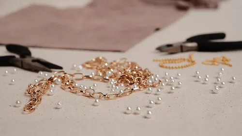Werkzeuge und Schmuckmaterialien auf einem Tisch.