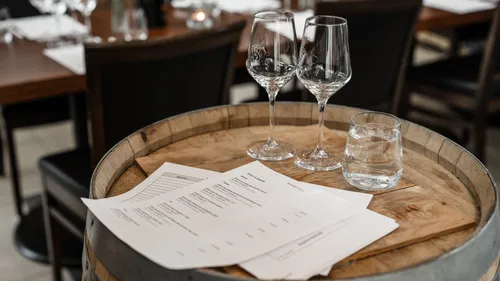 Wine glasses on barrel with menus.