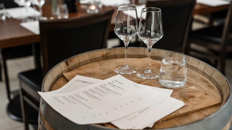Weingläser auf Fass mit Speisekarten.