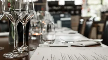 Weingläser auf gedecktem Restauranttisch.