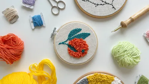 Embroidery supplies and a floral design on table.