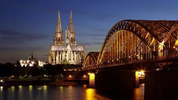 Cathedral and bridge lit up at night.