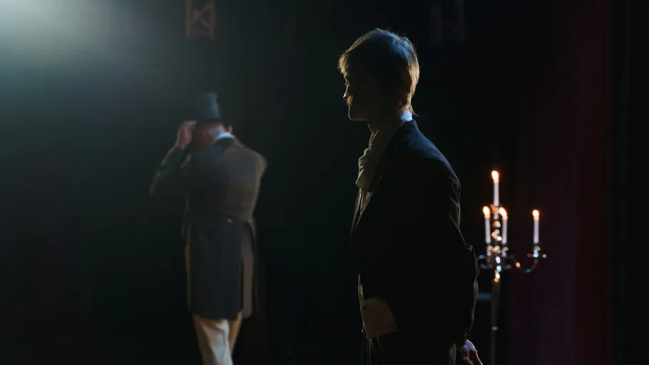 Zwei Schauspieler auf der Bühne bei schwachem Licht.