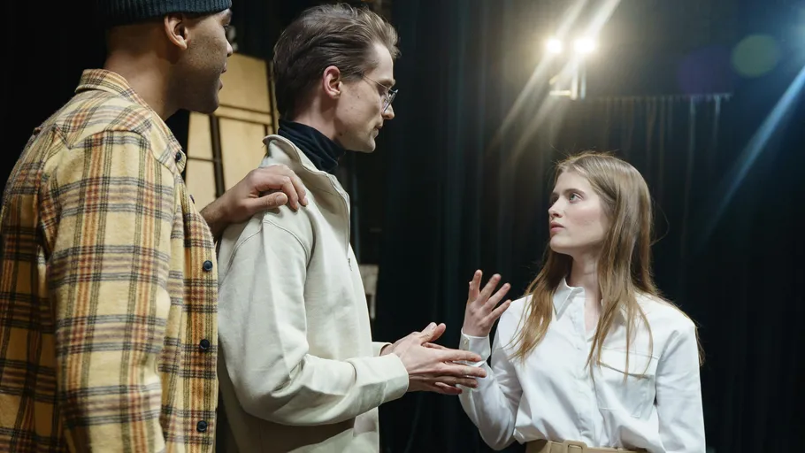 Three people talking on stage rehearsal.