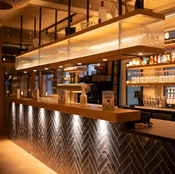 Modern bar interior with illuminated shelves.