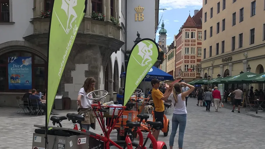 People with bicycles in a historic city street.
