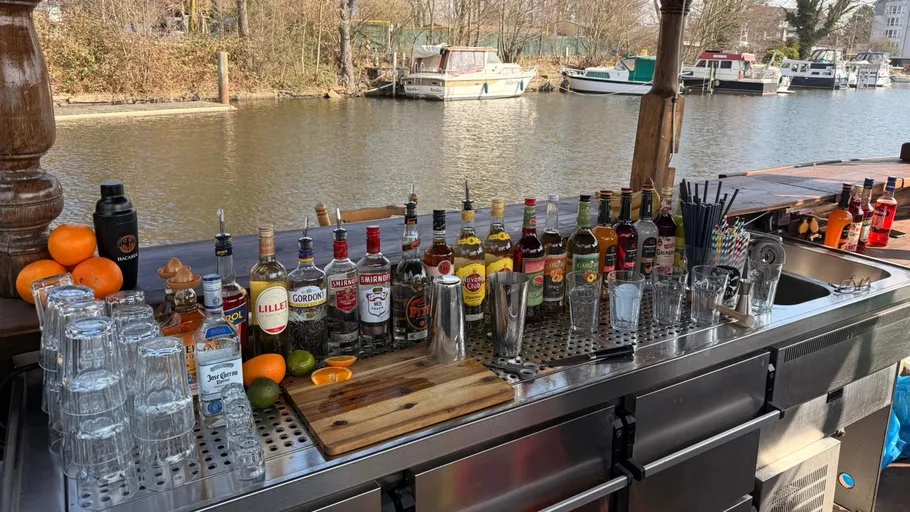 Outdoor-Bar mit Getränken am Flussufer.