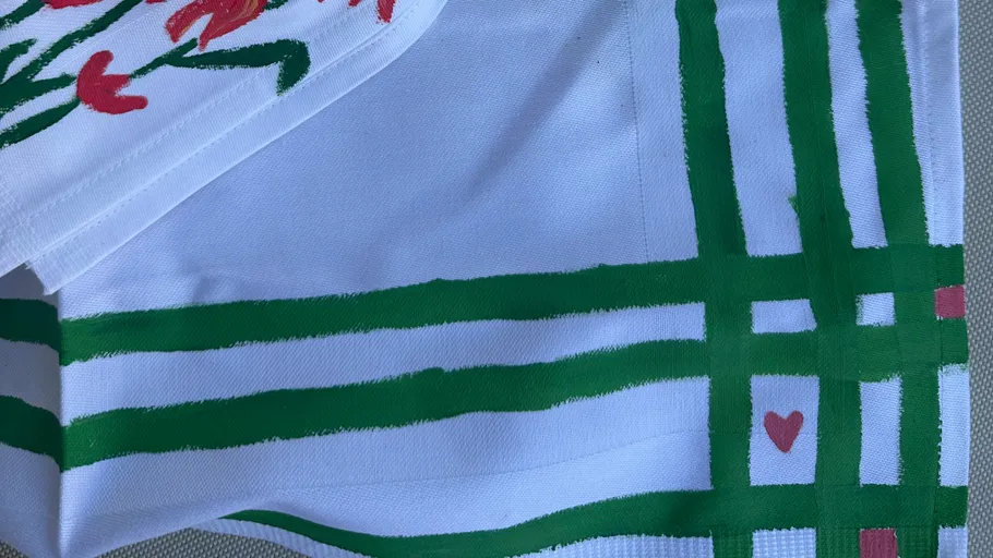 White cloth with green stripes and hearts.