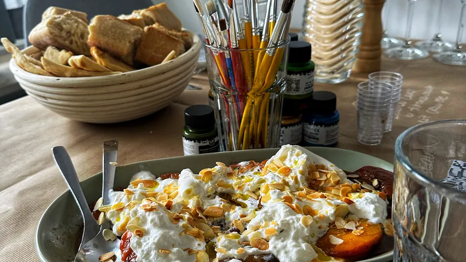 Dessert with whipped cream and almonds on table.