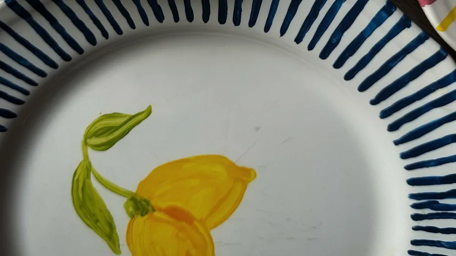 Plate with lemon design, blue striped rim.