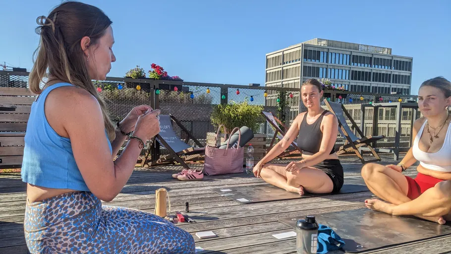Women practicing yoga on a rooftop deck.
