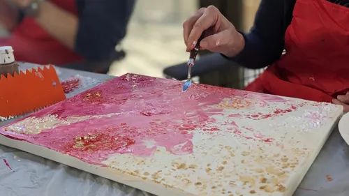 Person painting abstract canvas, table setting.