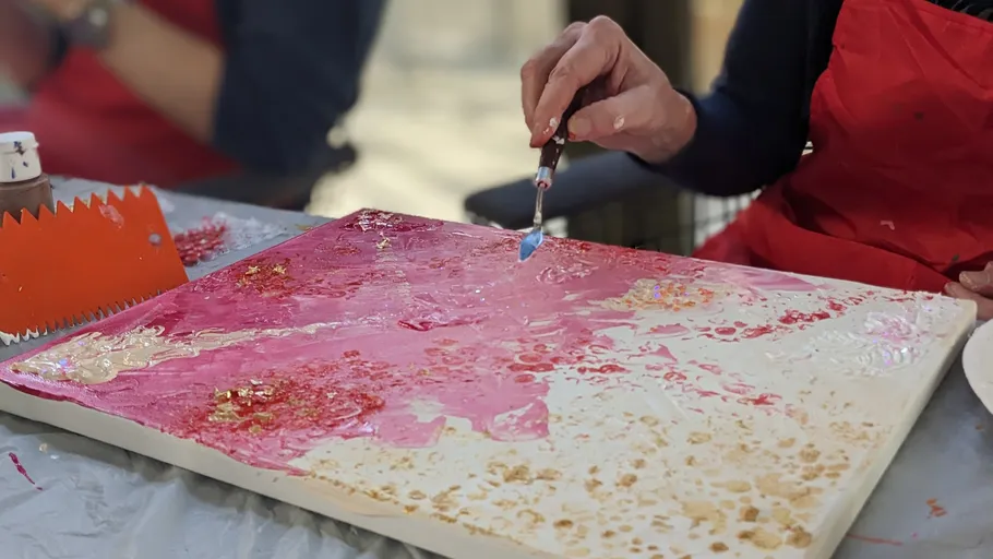 Person painting abstract canvas, table setting.