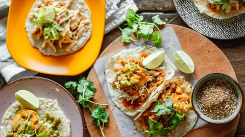 Tacos mit Belägen auf Holztisch.