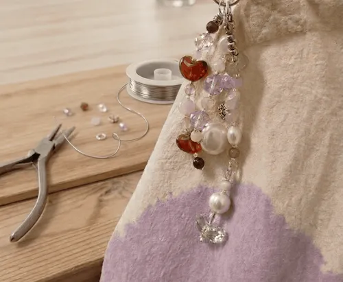 Beaded keychain on a bag next to tools.