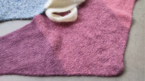 Mehrfarbiger Strickstoff auf einer Oberfläche.