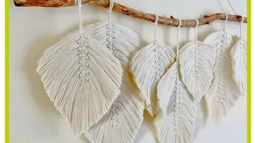 Macrame leaves hanging on a wooden branch.