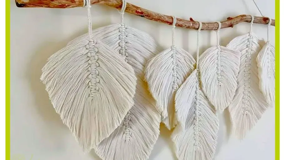 Macrame leaves hanging on a wooden branch.