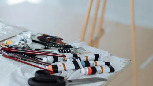 Art supplies scattered on wooden table.