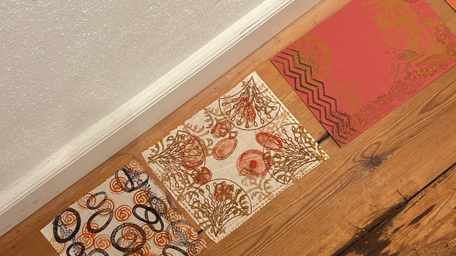 Three decorative papers on a wooden floor.