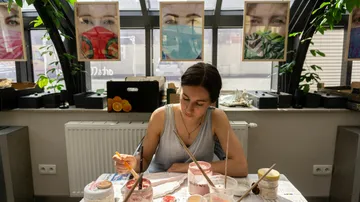 Woman painting at a table in a studio.