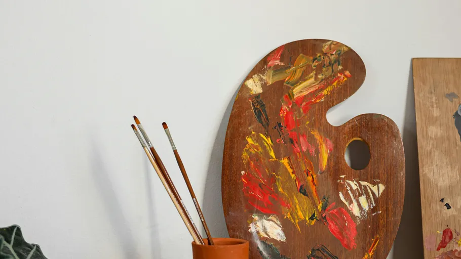 Farbpalette mit Pinseln auf Tisch.