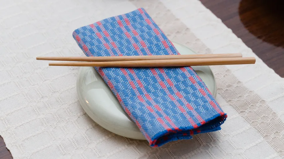 Chopsticks on folded napkin and coaster.