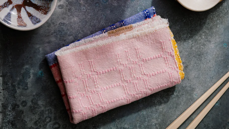 Pink patterned napkin on gray surface.