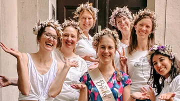 Gruppe von Frauen mit Blumenkronen, die lächeln.