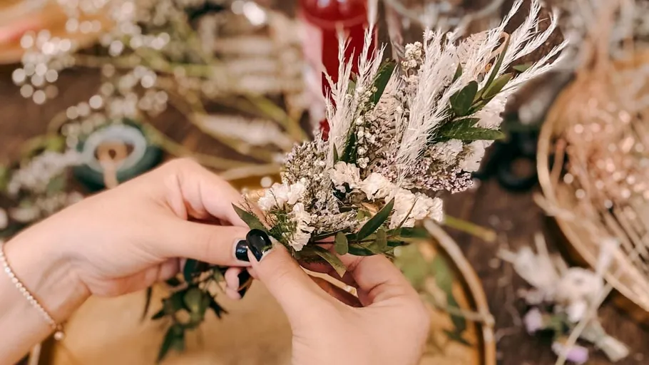 Hands arranging a dried flower bouquet.