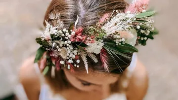 Woman wearing a floral crown indoors.