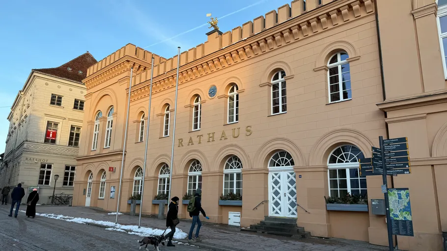 Rathaus-Gebäude mit Spaziergängern draußen.