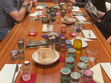 Tisch mit Gewürzen, Brot und Wasser in geselligem Umfeld.