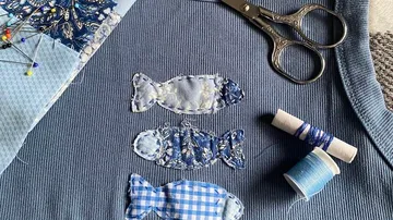 Stofffische auf blauem Textilhintergrund genäht.