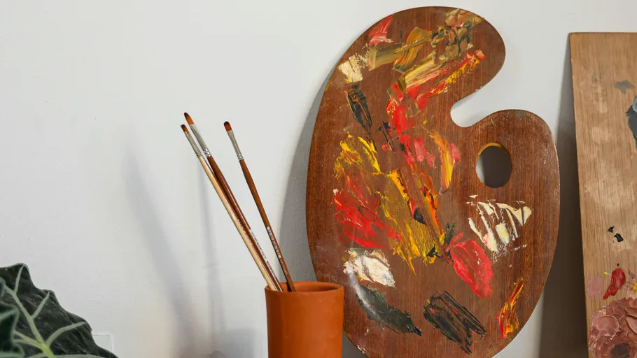 Farbpalette mit Pinseln im Glas.