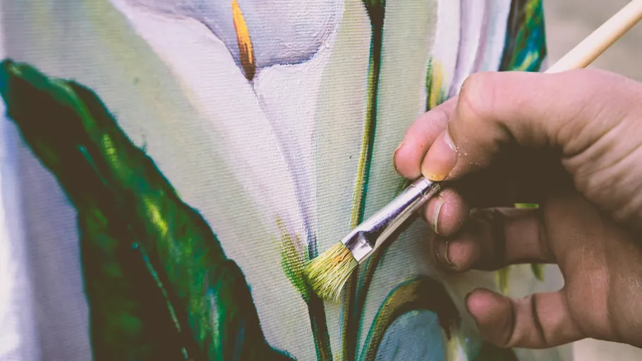 Hand painting flower on canvas closely.