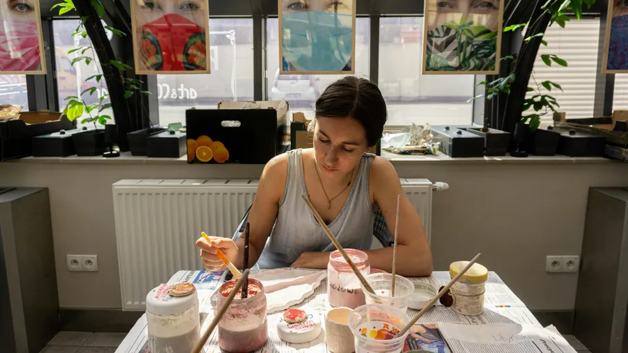 Frau malt in einem sonnenbeschienenen Atelier.