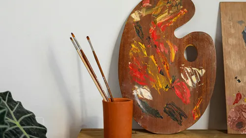 Malerpalette mit Pinseln auf einem Tisch.