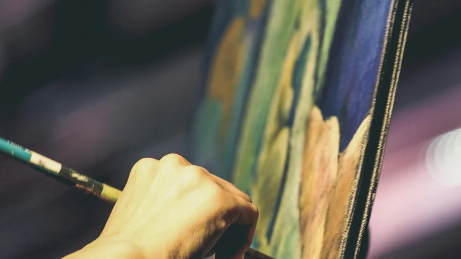 Person painting on canvas indoors.