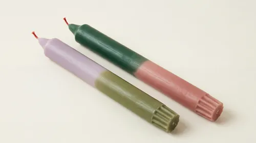 Two colorful candles on a white surface.