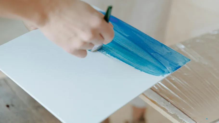 Hand painting blue on white canvas.
