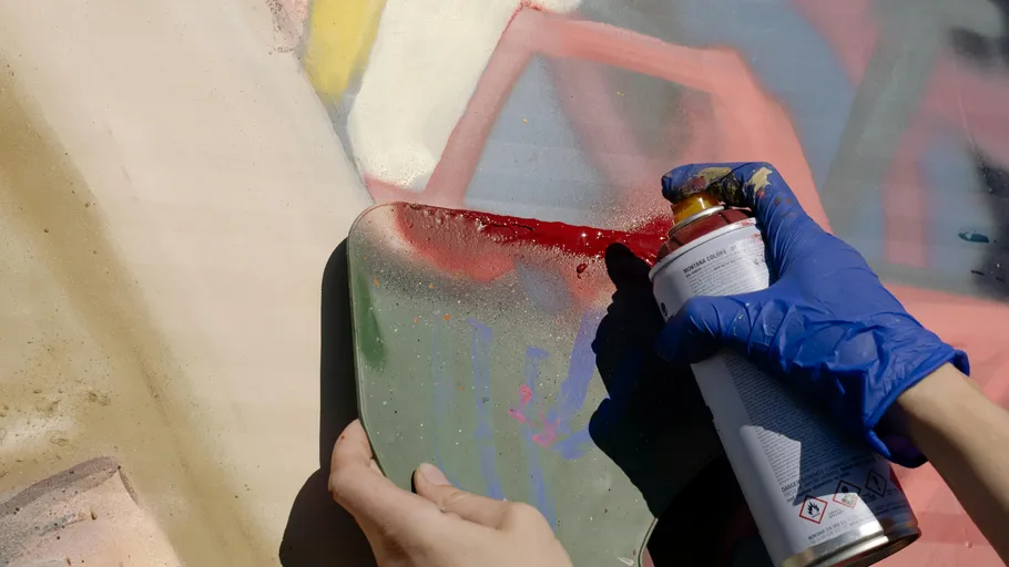 Hände besprühen Wand mit Graffiti.