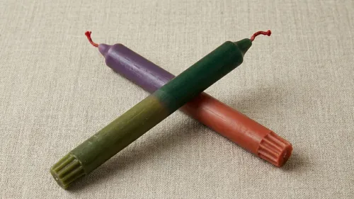 Zwei bunte Kerzen auf Texturoberfläche.