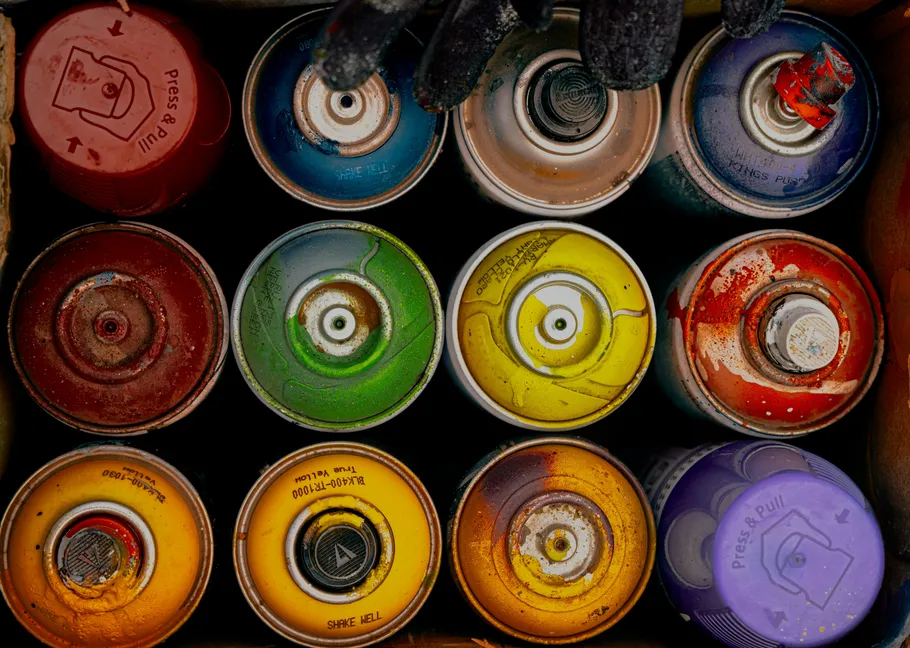 Colorful spray paint cans in a box.