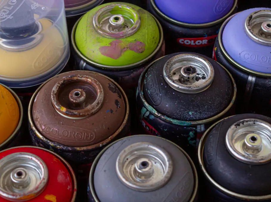 Spray paint cans, varied colors, close-up view.