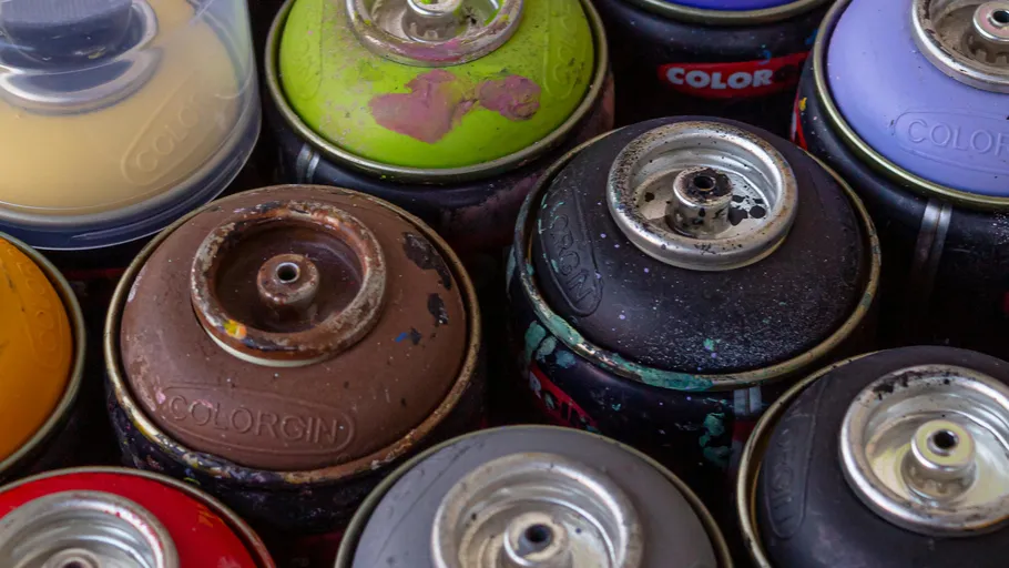 Colorful spray paint cans in close-up view.