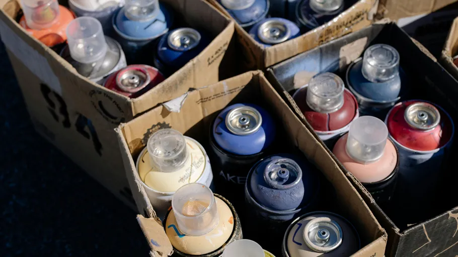 Colorful spray paint cans in cardboard boxes.