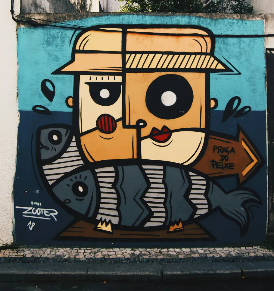 Colorful mural of face and fish on a wall.