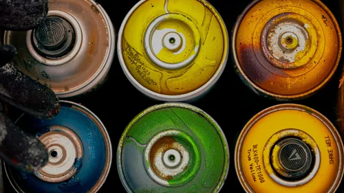 Six colorful spray paint cans overhead view.